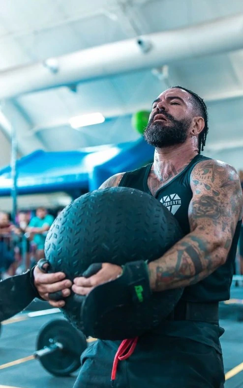 Atleta de CrossFit durante exercício com uma bola.